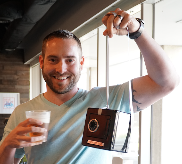 Employee holding up mini safe on string
