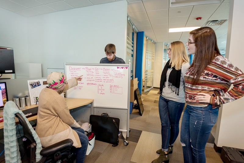 ABT employees around design white board
